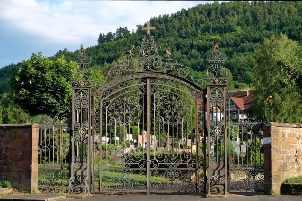 Portail entièrement forgé pour sécuriser l'entrée d'un cimetière en Savoie.