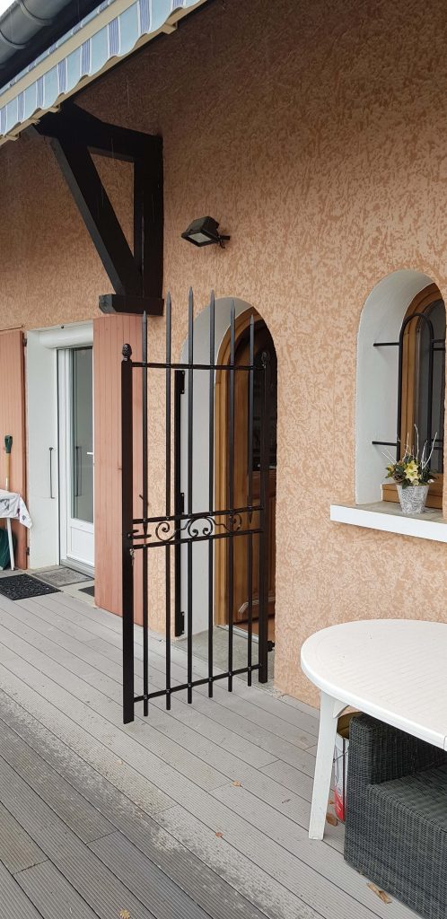 Grille ouvrante forgée entièrement rabattable sur la façade pour une villa sur les hauteur de Gap, finition noir mat